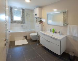 ein Badezimmer mit Badewanne, Toilette und Waschbecken in der Unterkunft Apartments Diamond in Podstrana