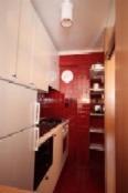 a kitchen with red walls and a red hallway at Campiglio Tre Sassi in Madonna di Campiglio