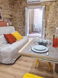 een woonkamer met een tafel en een bank bij Studio plein centre-ville 2 in Nîmes