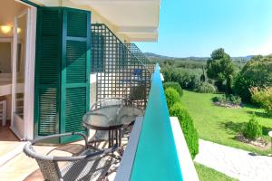 a balcony with two chairs and a view of a yard at Julia Hotel in Fourka