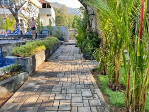 a stone walkway next to a swimming pool at Solaluna Beach Homestay in Amed