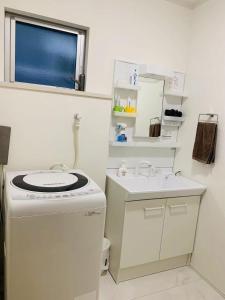a small white bathroom with a sink and a washing machine at Maisonette Hanazono - Vacation STAY 63319v in Kemigawa-machi