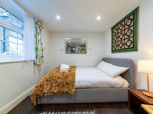 a bedroom with a bed and a window at Pass the Keys Cozy studio flat in trendy Brixton in London