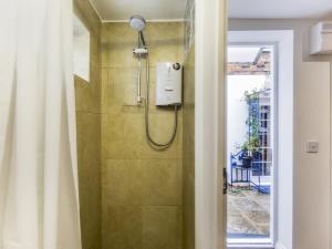 La salle de bains est pourvue d'une douche avec un pommeau de douche. dans l'établissement Pass the Keys Cozy studio flat in trendy Brixton, à Londres