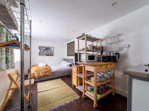 Habitación pequeña con cama y microondas. en Pass the Keys Cozy studio flat in trendy Brixton en Londres