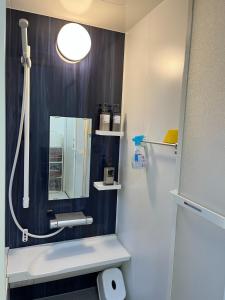 Maisonette Hanazono - Vacation STAY 63319v في Kemigawa-machi: حمام مع مرآة ومغسلة بيضاء