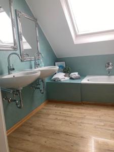 a bathroom with two sinks and a bath tub at Astentraum in Winterberg