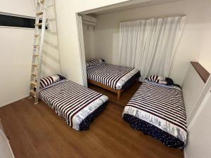 a room with two beds and a ladder in it at Maisonette Hanazono - Vacation STAY 63319v in Kemigawa-machi