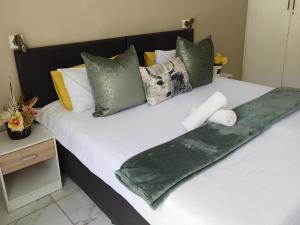 a bed with pillows and a roll of toilet paper on it at Lesedi Guesthouse Middleburg in Middelburg