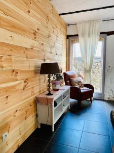 una camera con una parete in legno, una lampada e una sedia di B&B Villa Belle Epoque a Durbuy