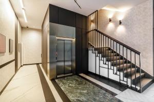 een hal met een trap en een lobby met een groen tapijt bij Plac Unii Centrum - Comfy Apartments in Gdynia +41 foto's