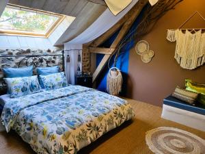 um quarto com uma cama com uma colcha azul e branca em Les Causeries du Monde em Chamboulive
