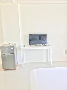 a white room with a table with a television on it at Vargas Apartelle in Boracay
