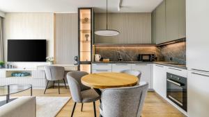 een keuken met een houten tafel en stoelen bij Plac Unii Centrum - Comfy Apartments in Gdynia