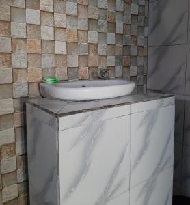 lavabo blanco en la parte superior de un armario en el baño en New Taman Sari Homestay, en Pawenang