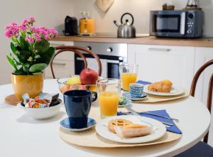 a table with breakfast foods and orange juice at AI PALMENTI B&B in Adelfia