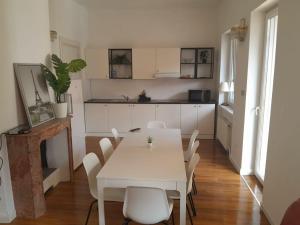 a dining room with a white table and white chairs at Rooms Miklošičeva in Ljubljana