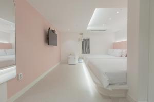 a white bedroom with a large bed and a mirror at MJ Stay 2 in Seoul