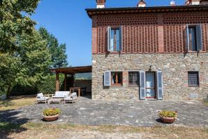 ein Steinhaus mit 2 Stühlen und einer Terrasse in der Unterkunft Fienile panoramico nel Chianti in Greve in Chianti
