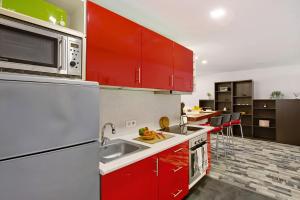 a kitchen with red cabinets and a microwave at San Fernando Apartment in San Bartolomé