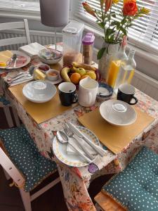 a table with plates and utensils on top at Home from Home Cosy B&B in London
