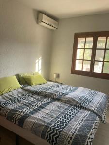 een bed met een blauw en wit dekbed in een slaapkamer bij Nice holiday house with pool at La Sella Golf between Denia and Javea in Pedreguer