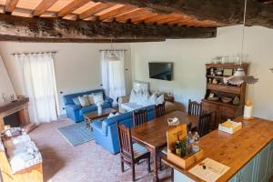 ein Wohnzimmer mit einem blauen Sofa und einem Tisch in der Unterkunft Fienile panoramico nel Chianti in Greve in Chianti