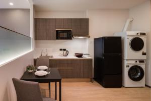 a kitchen with a black refrigerator and a table at Samyan Serene Hotel in Bangkok +50 photos