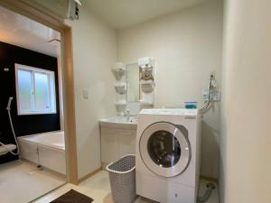 een badkamer met een wasmachine en een wastafel bij 南あその丘 in Shimoda