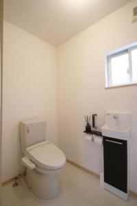 biała łazienka z toaletą i umywalką w obiekcie 南あその丘 w mieście Shimoda