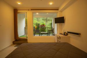 a bedroom with a bed and a view of a balcony at Teaberg Estate Haus in Munnar