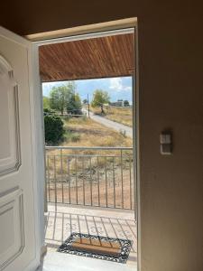 a door to a balcony with a view of a field at Xenia's Seaview House in Paralía Avlídhos