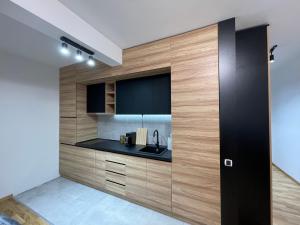 una cocina con armarios de madera y fregadero en MAR Residence 5 en Niš