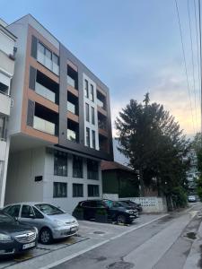 un estacionamiento con autos estacionados frente a un edificio en MAR Residence 5 en Niš