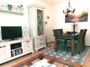 ein Wohnzimmer mit Tisch und Fernseher in der Unterkunft Ferienwohnung Dünenweg Piepen in Heringsdorf