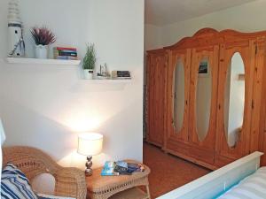 ein Schlafzimmer mit einem Holzschrank und einem Tisch mit einer Lampe in der Unterkunft Ferienwohnung Dünenweg Piepen in Heringsdorf + 8 Fotos