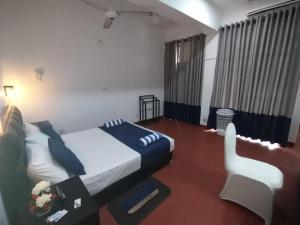 WatumullaにあるHotel Mount Lankaのベッドルーム1室(ベッド1台、椅子付)