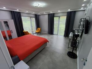 a bedroom with a red bed and a table and chairs at VillaZ Villa Ardeşen in Ardeşen