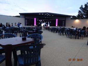 un groupe de tables et de chaises avec des personnes dans un bâtiment dans l'établissement Maison tout confort 4 ch 8p domaine privé avec piscines, et plage à 10 min à pied, à Portiragnes 45 autres photos