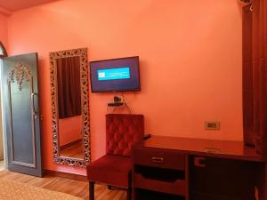 a living room with a television and a mirror at Maya Hotel & Restaurant in Agra