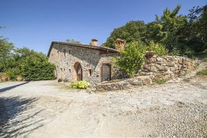 an old stone house on a dirt road at Podere Le Ghiande in CastellʼAzzara