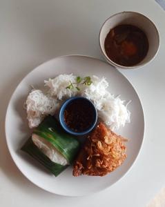 a plate of food with rice and a bowl of sauce at 8IK88 Resort - SHA Extra Plus in Por Bay