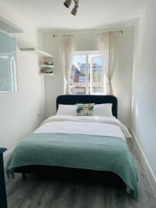 Un dormitorio con una cama grande con ventana. en Stunning huge openplan 2Bed flat, en Woking