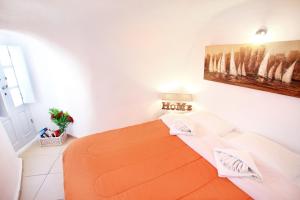 a bedroom with a white bed and white walls at Prime Suites in Oia
