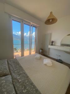 a bedroom with a bed with a view of the ocean at ORO, 8 in Bellano