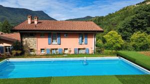 a house with a swimming pool in front of a house at Borgo alla Sorgente in Vallio Terme