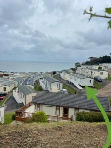 a row of houses on a hill with a green arrow at Modern Luxurious Holiday Home with ocean views in Paignton