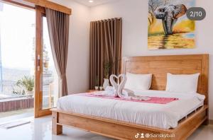 um quarto com uma cama com uma fotografia de elefante na parede em Sari Sky Bali em Kubupenlokan