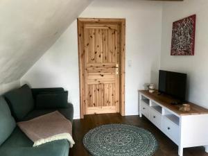 a living room with a couch and a television at Ferienwohnung in der Uckermark am Oberuckersee OT Warnitz in Warnitz