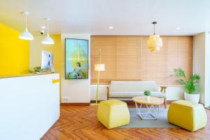 a living room with a couch and a table and chairs at Bloom Hotel - Cyber Towers in Hyderabad